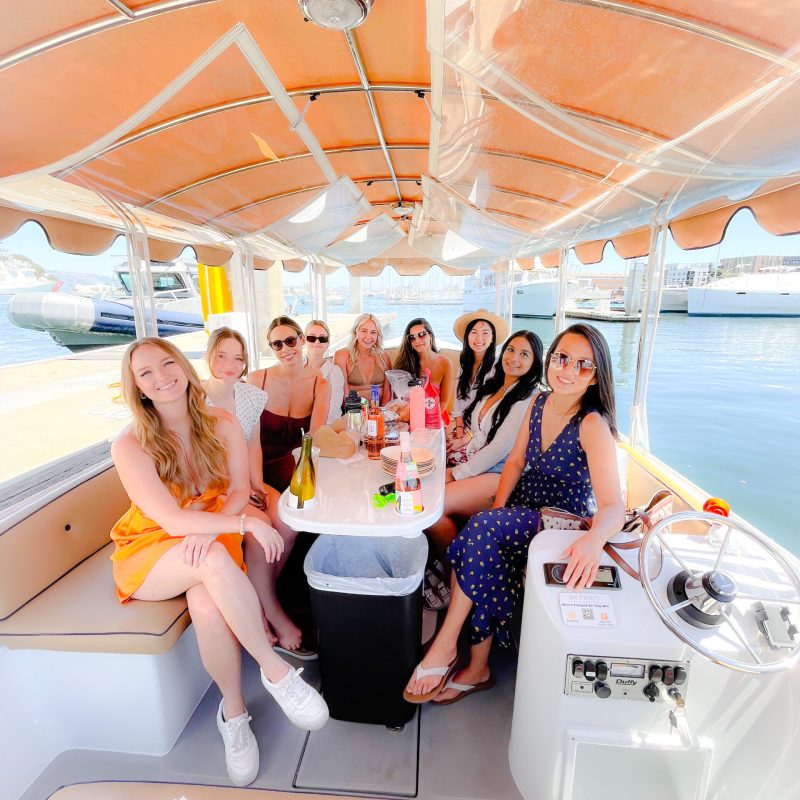 a group of people sitting at a table with a cake