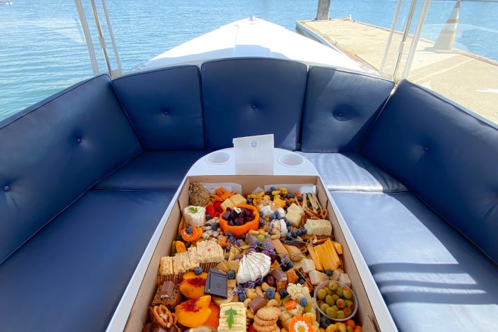 a pizza sitting on top of a boat next to a body of water